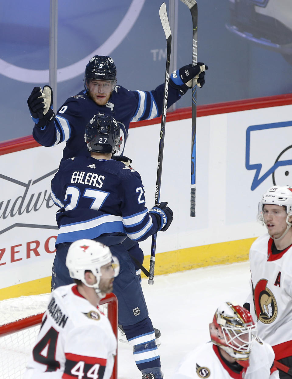 Winnipeg Jets' Andrew Copp (9) and Nikolaj Ehlers (27) celebrate Copp's goal against the Ottawa Senators during the third period of an NHL hockey game Saturday, Jan. 23, 2021, in Winnipeg, Manitoba. (John Woods/The Canadian Press via AP)