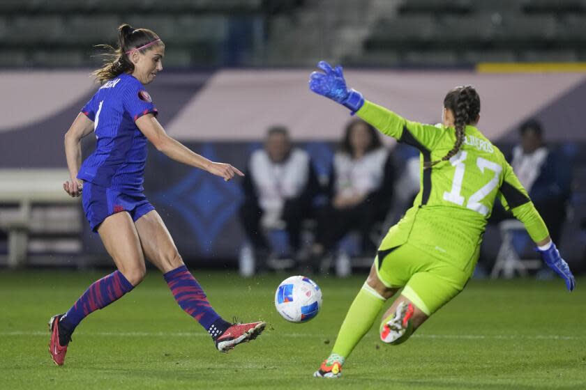 U.S. forward Alex Morgan, left, shoots against Argentina goalkeeper Laurina Oliveros during the first half of a CONCACAF Gold Cup women's soccer tournament match Friday, Feb. 23, 2024, in Carson, Calif. (AP Photo/Ryan Sun)