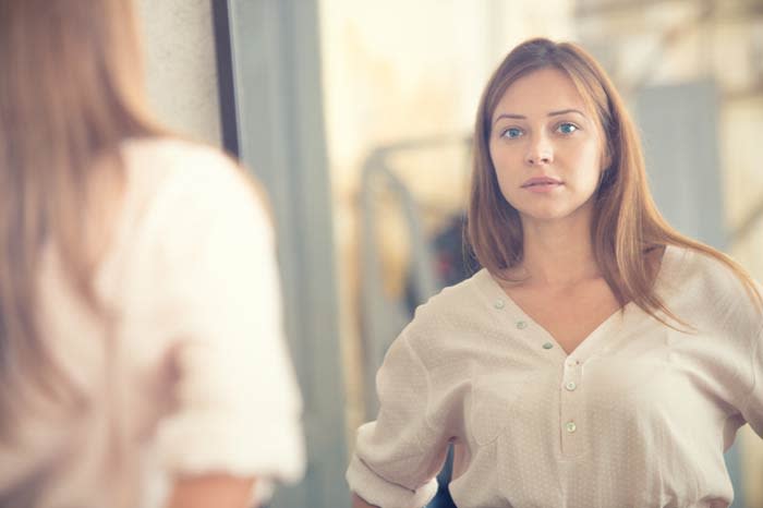 mujer mirándose en un espejo