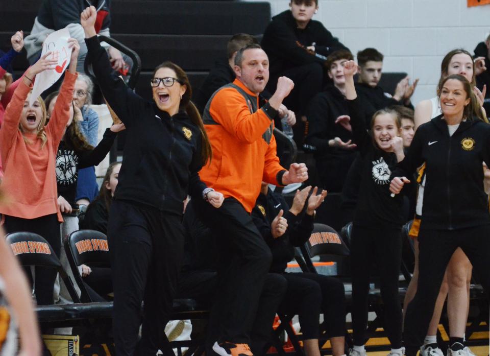 Harbor Springs basketball coaches (from left) Jen Foley, John Flynn and Amy Flynn celebrate a 3-pointer by sophomore guard Olivia Flynn in the first half of Monday's game.