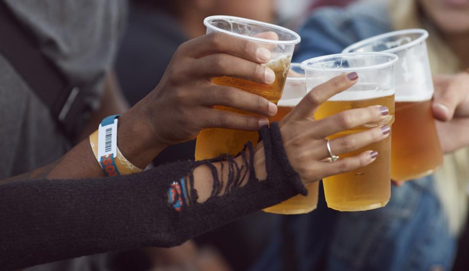 Women holding beers outdoors.