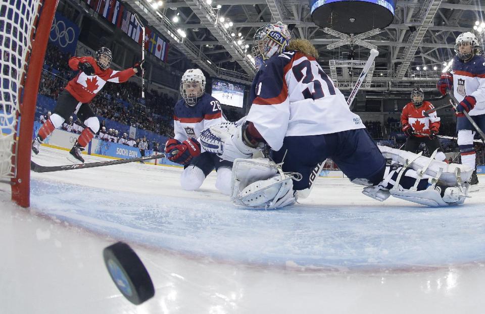 Goalkeeper Jessie Vetter and Kendall Coyne (26) of the United States look back at the puck as Meghan Agosta-Marciano, left, of Canada celebrates her goal during women's ice hockey game at the 2014 Winter Olympics, Wednesday, Feb. 12, 2014, in Sochi, Russia. Canada defeated the United States 3-2. (AP Photo/Matt Slocum, Pool)