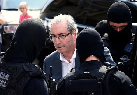 FILE PHOTO: Former speaker of Brazil's Lower House of Congress, Eduardo Cunha (C), is escorted by federal police officers as he leaves the Institute of Forensic Science in Curitiba, Brazil, October 20, 2016. REUTERS/Rodolfo Buhrer/File photo