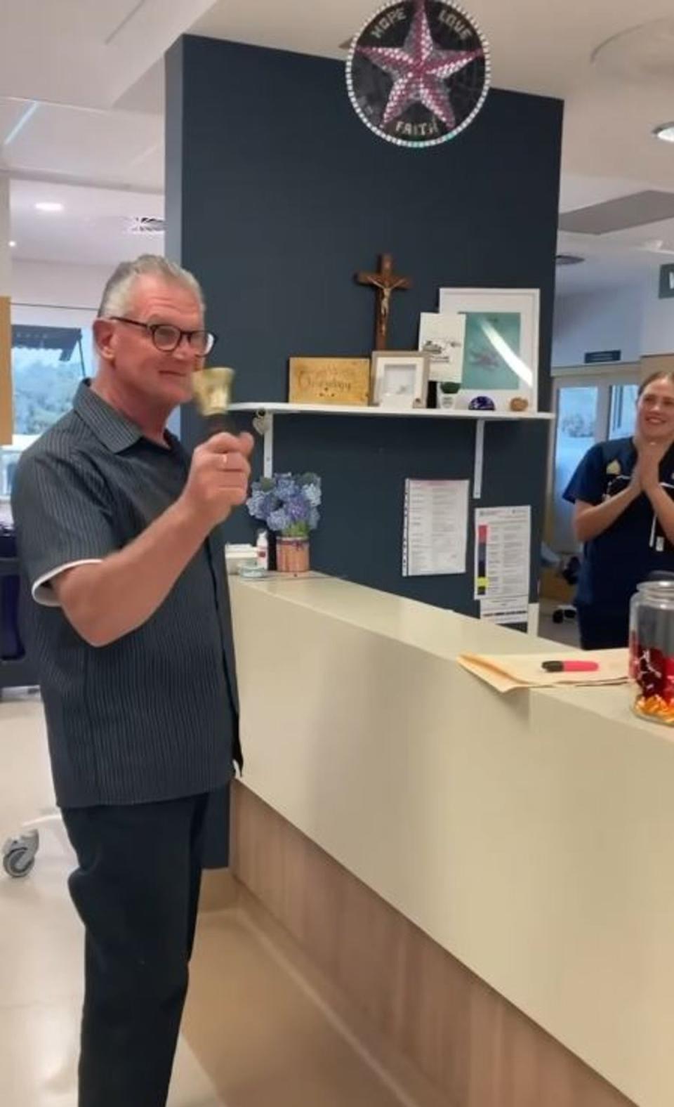 Dianne Buswell shared a picture of her dad ringing a bell to signal the end of his chemotherapy treatment (Instagram @diannebuswell)