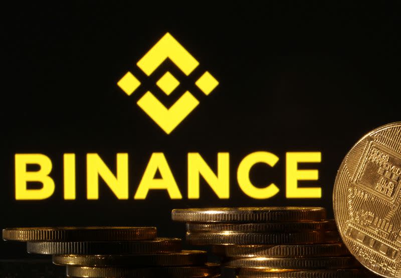 Illustration shows Binance logo and representation of cryptocurrencies