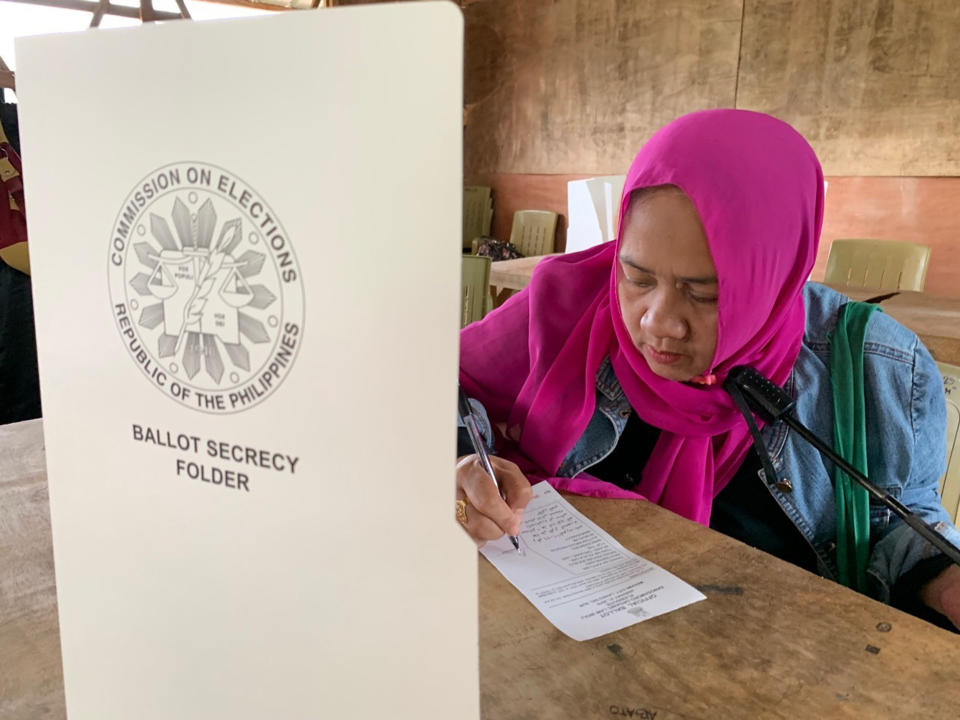 A Muslim woman writes down to vote in a referendum at the Marawi Sagonsongan elementary school-turned polling station in Marawi, Lanao del Sur province, southern Philippines, Monday, Jan. 21, 2019. Muslims in the southern Philippines voted Monday in a referendum on a new autonomous region that seeks to end nearly half a century of unrest, in what their leaders are touting as the best alternative to a new wave of Islamic State group-inspired militants. (AP Photo/Bogie Calupitan)