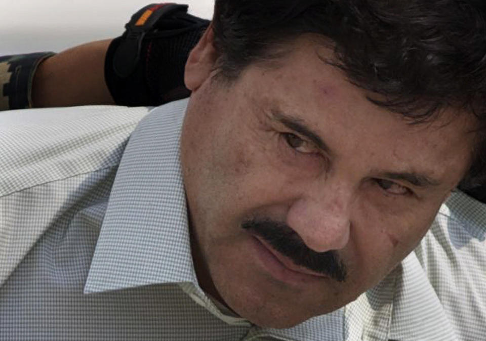 Joaquín "El Chapo" Guzmán es escoltado a un helicóptero de la Policía Federal por infantes de Marina mexicanos en un hangar de la Marina en la Ciudad de México el sábado 22 de febrero de 2014. (Foto AP/Eduardo Verdugo)