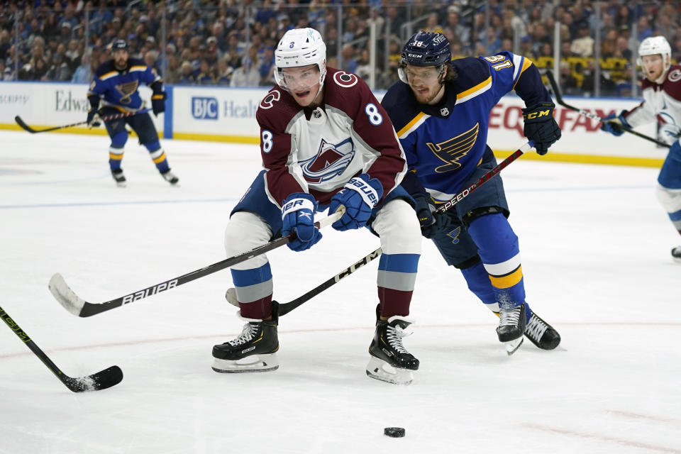 Colorado Avalanche's Cale Makar (8) and St. Louis Blues' Robert Thomas (18) battle for a loose puck during the second period in Game 3 of an NHL hockey Stanley Cup second-round playoff series Saturday, May 21, 2022, in St. Louis. (AP Photo/Jeff Roberson)