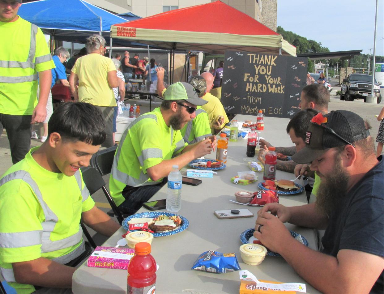 A sign at the end of the table shares a message of thanks to the utility workers in Holmes County. The workers were treated to a picnic.