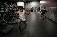 Nelson Lemus, left, and Azucena Quintanilla wear masks while exercising at a gym in Los Angeles. Friday, June 26, 2020. With the coronavirus surging, at least four California counties on Friday paused or prepared to backtrack on their reopening plans in a bid to halt the spread of the virus. (AP Photo/Jae C. Hong)