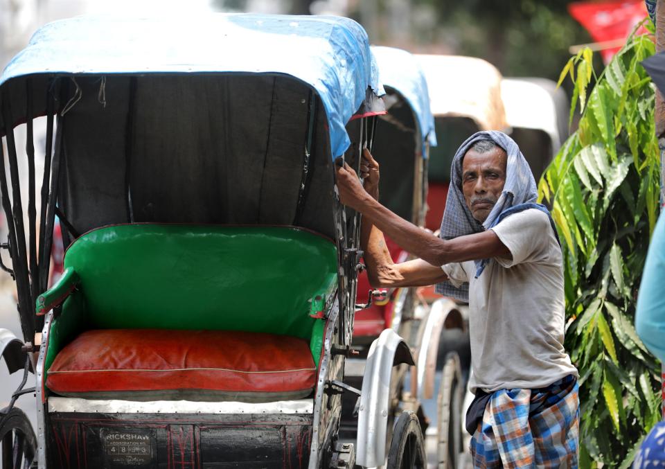 An Indian rikshaw puller waits during a hot afternoon in Kolkata, eastern India, 19 April 2022 (EPA)