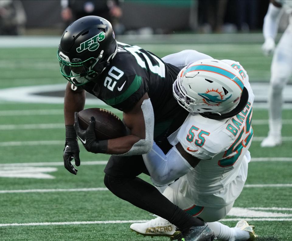 Jerome Baker tackles Breece Hall of the Jets.