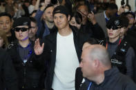 CORRECTS DATE - Los Angeles Dodgers' Shohei Ohtani gestures as he walks with security guards during the baseball team's arrival at Incheon International Airport, Friday, March 15, 2024, in Incheon, South Korea, ahead of the team's baseball series against the San Diego Padres. (AP Photo/Lee Jin-man)