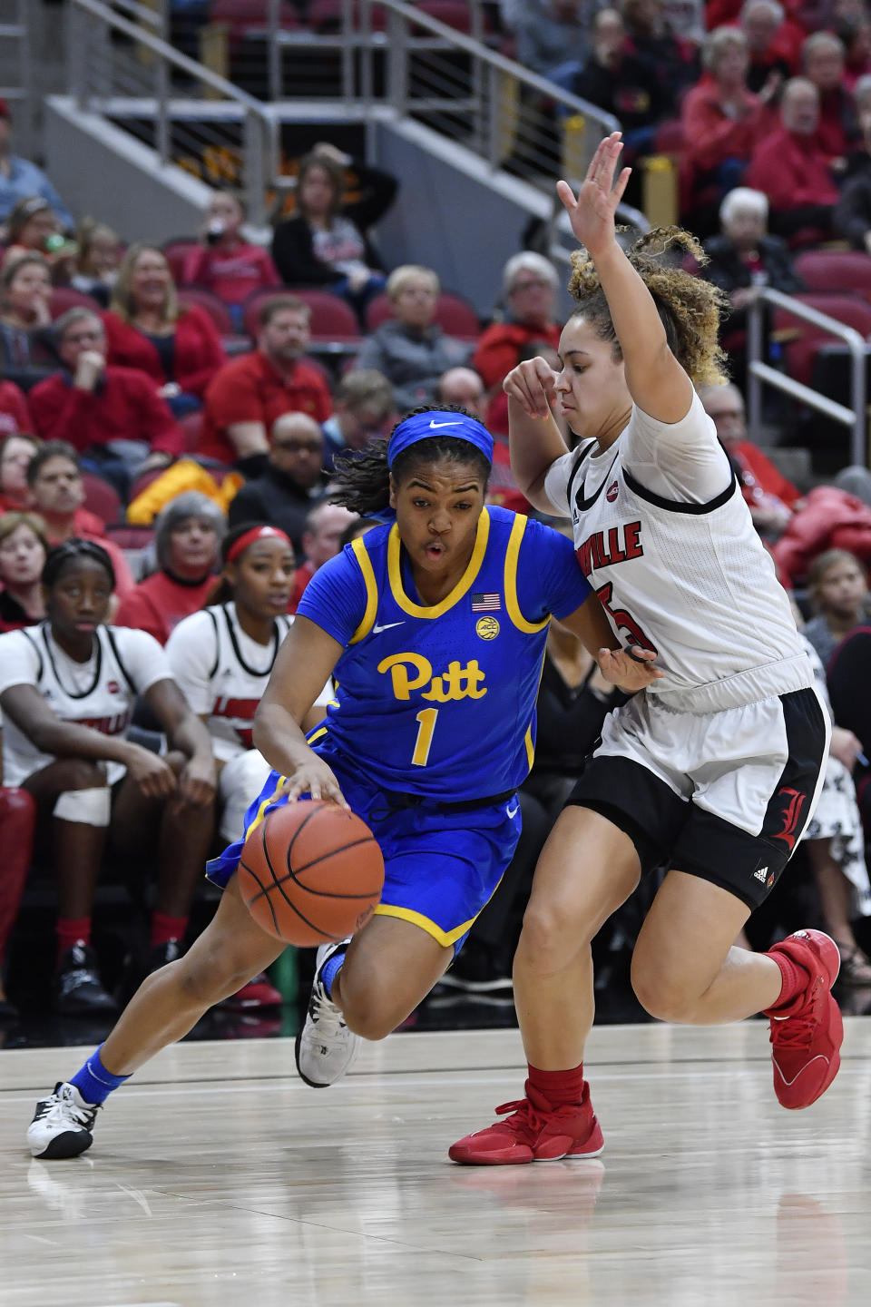 Pittsburgh guard Dayshanette Harris (1) drives around Louisville guard Mykasa Robinson (5) during the first half of an NCAA college basketball game in Louisville, Ky., Sunday, Jan. 26, 2020. (AP Photo/Timothy D. Easley)