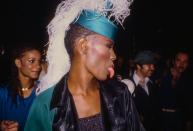 <p>Grace Jones gets cheeky with her fans as she greets them at the Electric Circus nightclub in New York City. The singer donned a chic and elaborate feathered hat for the occasion.</p>
