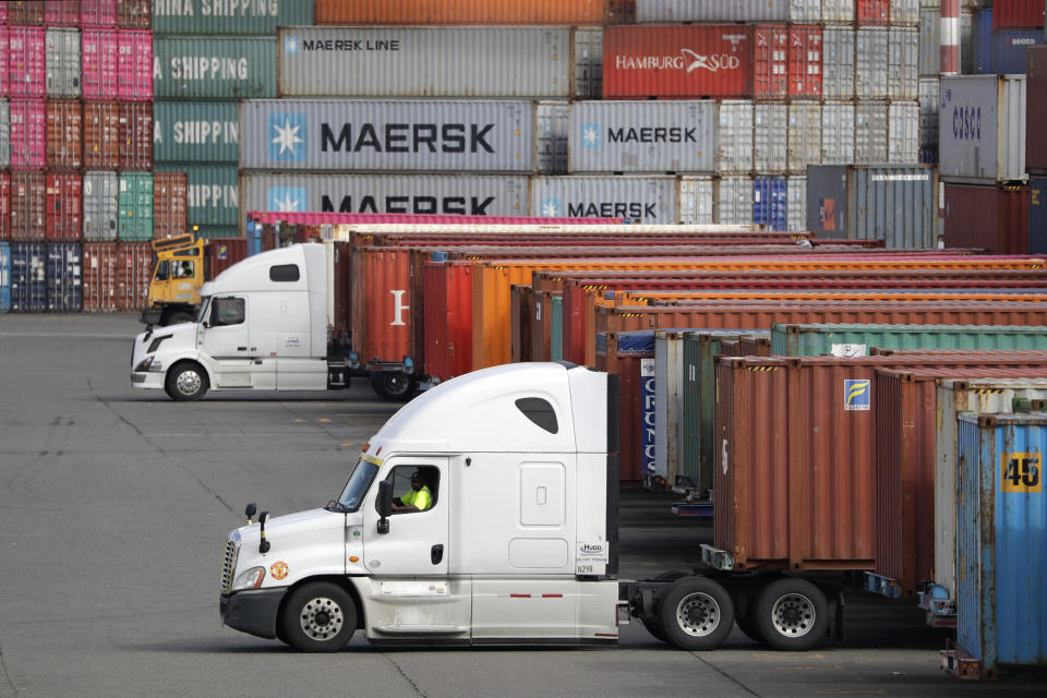 FILE - In this Oct. 2, 2019, file photo trucks are positioned to haul shipping containers at a terminal where containers are stacked five-high on Harbor Island in Seattle. On Friday, Dec. 20, the Commerce Department issues the third estimate of how the U.S. economy performed in the July-September quarter (AP Photo/Elaine Thompson, File)
