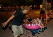 People tend to an injured woman after an explosion at the Formosa Fun Coast amusement park in the Pali district of New Taipei City on June 27, 2015