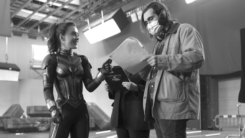 Kathryn Newton in costume and Jeff Loveness with a surgical mask on behind the scenes of Ant-Man and The Wasp: Quantumania