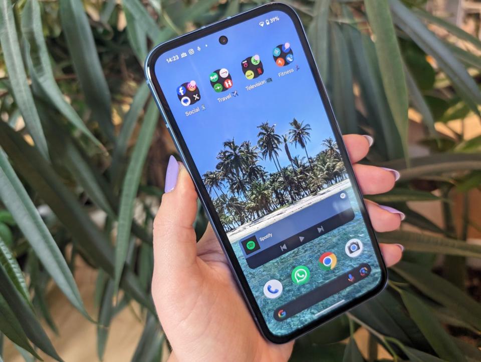 Google Pixel 8a held in hand with purple nails