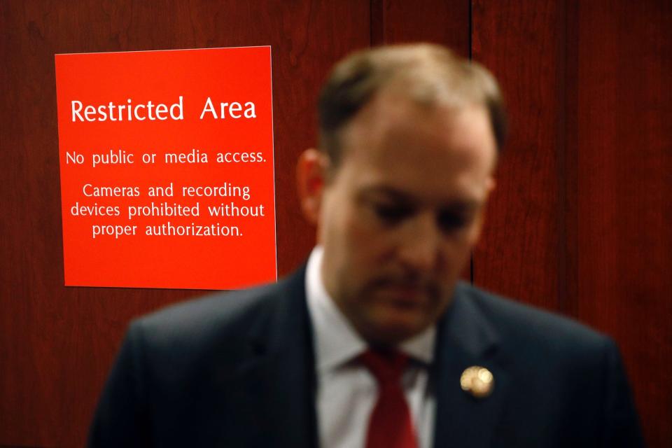 A sign marks a door to a secure area behind Rep. Lee Zeldin.