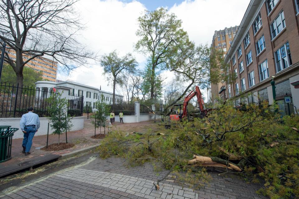 City of Jackson employees clear a tree fallen from the property at the governor’s mansion in Jackson, Miss., March 3, 2023. The tree, toppled due to heavy wind as severe weather passed through the state Friday, blocked Congress Street and broke a window in a building across from the mansion. High winds left thousands of Mississippians without power.