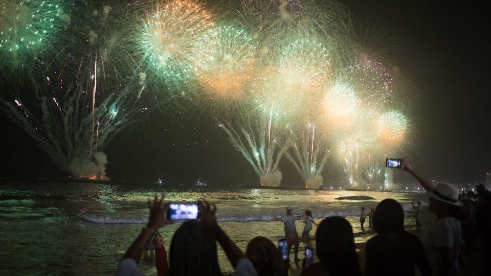 People celebrate as the traditional New Year's fireworks light up the sky at Copacabana Beach in Rio de Janeiro on January 1, 2023. - Pedro Prado/AFP/Getty Images