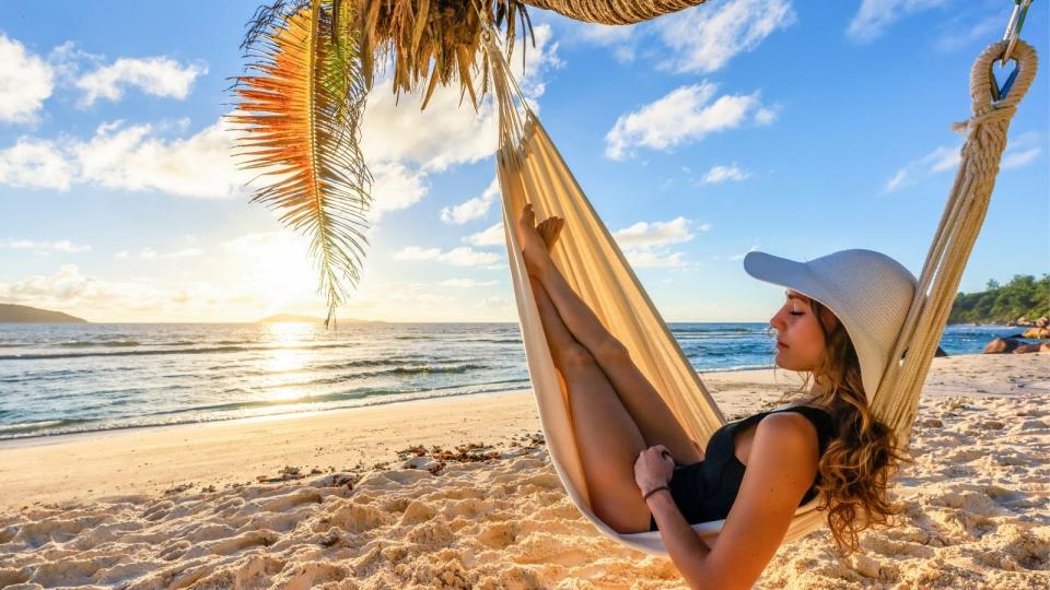 Woman in hammock on beach on holidays.