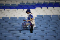 A fan of Japan picks up garbages at the end of the World Cup round of 16 soccer match between Japan and Croatia at the Al Janoub Stadium in Al Wakrah, Qatar, Monday, Dec. 5, 2022. (AP Photo/Eugene Hoshiko)