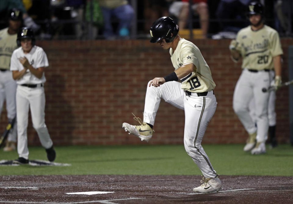 Vanderbilt's Pat DeMarco (18) stomps on home plate to score in the eighth inning of the team's NCAA college baseball tournament super regional game against Duke Saturday, June 8, 2019, in Nashville, Tenn. (AP Photo/Wade Payne)