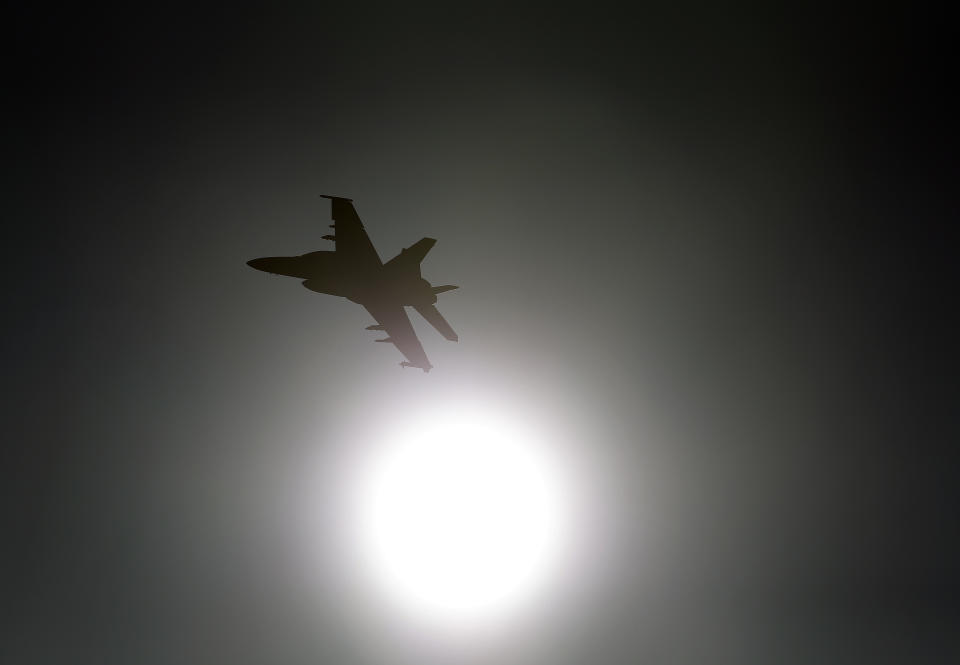In this Feb. 28, 2017, photo, Thomas "Tom" P. McGee of the VX-9 Vampire squadron from Naval Air Weapons Station China Lake, flies an F/A-18E Super Hornet toward the sun over Death Valley National Park, Calif. Military jets roaring over national parks have long drawn complaints from hikers and campers. But in California's Death Valley, the low-flying combat aircraft skillfully zipping between the craggy landscape has become a popular attraction in the 3.3 million acre park in the Mojave Desert, 260 miles east of Los Angeles. (AP Photo/Ben Margot)