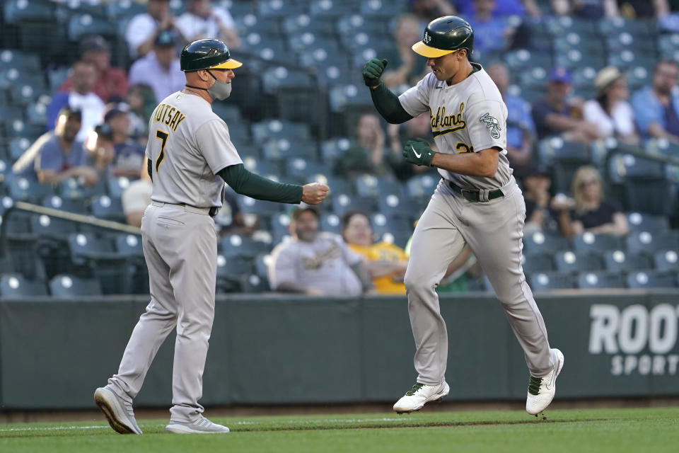Oakland Athletics' Matt Olson, right, is greeted by third base coach Mark Kotsay while running the bases after hitting a solo home run during the second inning of the team's baseball game against the Seattle Mariners, Tuesday, June 1, 2021, in Seattle. (AP Photo/Ted S. Warren)