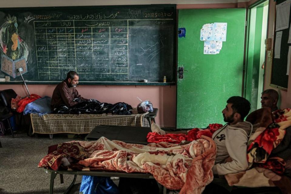 Injured Palestinian men sit in a classroom at the Ras Al-Naqoura school in Khan Yunis, in the southern Gaza Strip on 22 November, 2023, after being transferred from the Indonesian Hospital in northern Gaza.