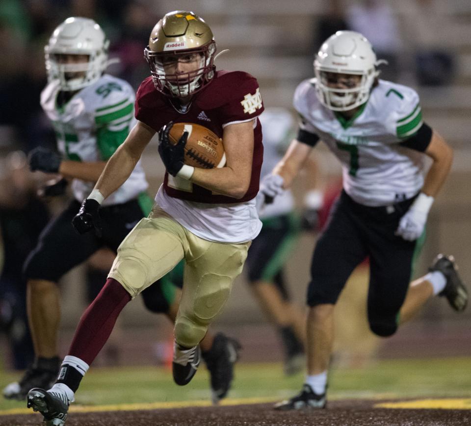 Mater Dei's Wyatt Stratman (24) runs the ball as Perry Central Commodores defenders pursue during the Mater Dei Wildcats vs Perry Central Commodores game at Central Stadium in Evansville, Ind., Friday evening, Oct. 21, 2022. 