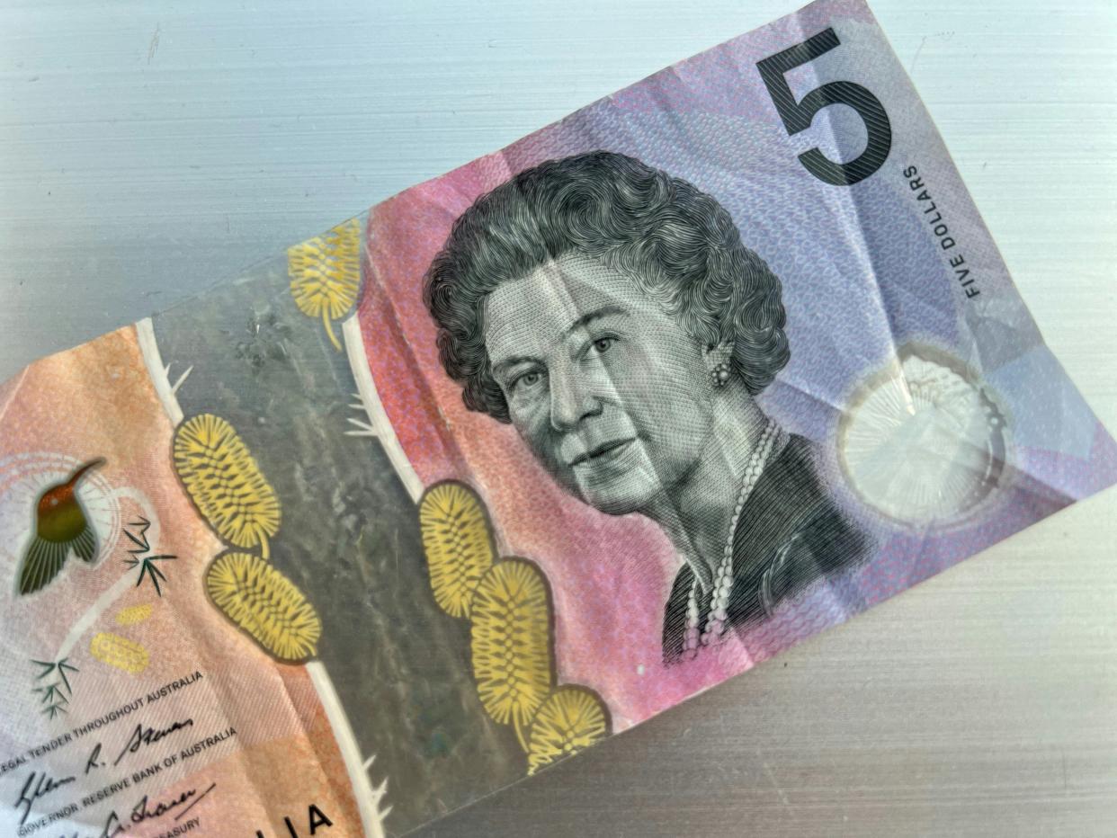 An Australian $5 bill that features a portrait of the late Queen Elizabeth II.