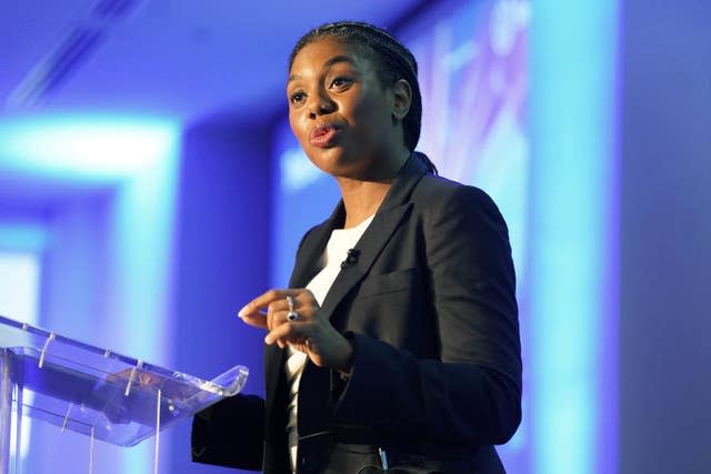 Business Secretary Kemi Badenoch stands at a podium as she delivers a speech at a conference 