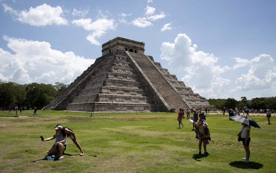 In this Aug. 3, 2018 photo, tourists walk at the Mayan ruins of Chichen Itza in Mexico's Yucatan Peninsula. Mexico's president-elect Andres Manuel Lopez Obrador wants to build a $3.2 billion train from the Yucatan Peninsula to Chiapas state to get tourists off the heavily travelled tourism route of Cancun-Riviera Maya-Chichen Itza-Xcaret visited by millions of tourists per year. (AP Photo/Eduardo Verdugo)