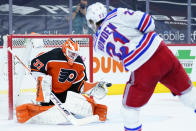 Philadelphia Flyers' Brian Elliott, left, blocks a shot by New York Rangers' Brett Howden during the second period of an NHL hockey game, Wednesday, Feb. 24, 2021, in Philadelphia. (AP Photo/Matt Slocum)