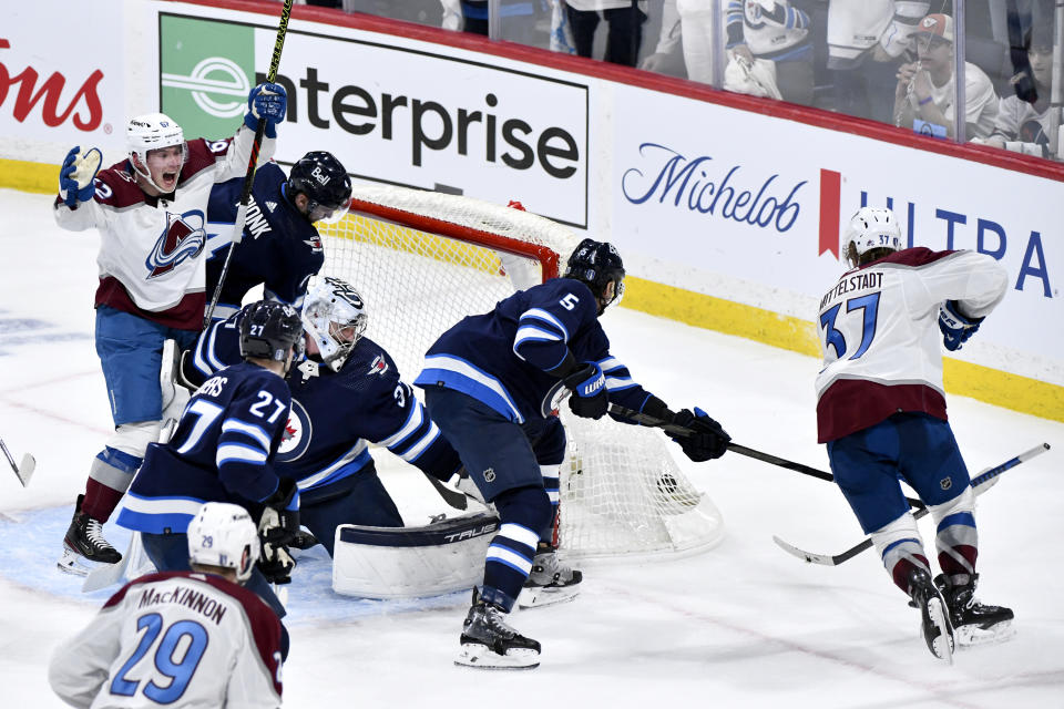 Colorado Avalanche left wing Artturi Lehkonen (62) celebrates the goal by Casey Mittelstadt (37) on Winnipeg Jets goaltender Connor Hellebuyck (37) during the third period in Game 1 of an NHL hockey Stanley Cup first-round playoff series in Winnipeg, Manitoba, Sunday, April 21, 2024. (Fred Greenslade/The Canadian Press via AP)