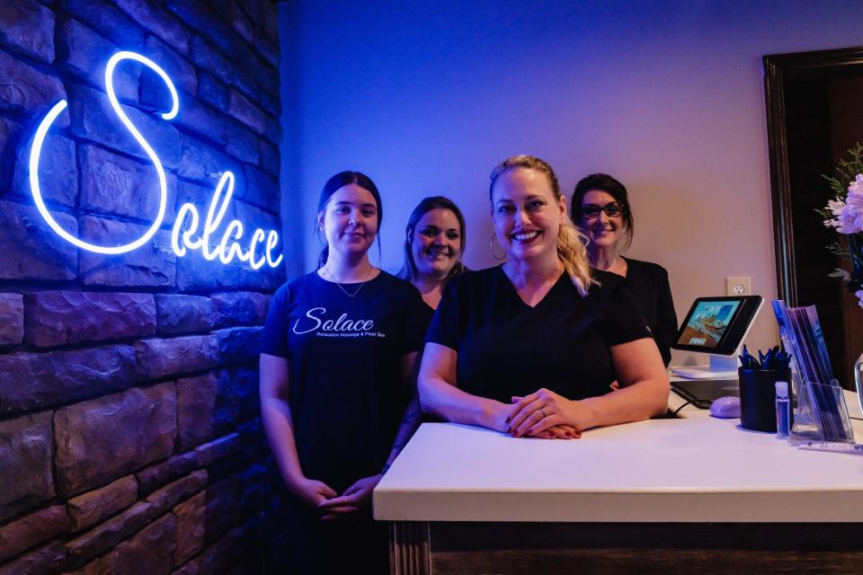 The Solace Relaxation Massage & Float Spa staff pose for a portrait at the front desk of the newly relocated spa in New Philadelphia.