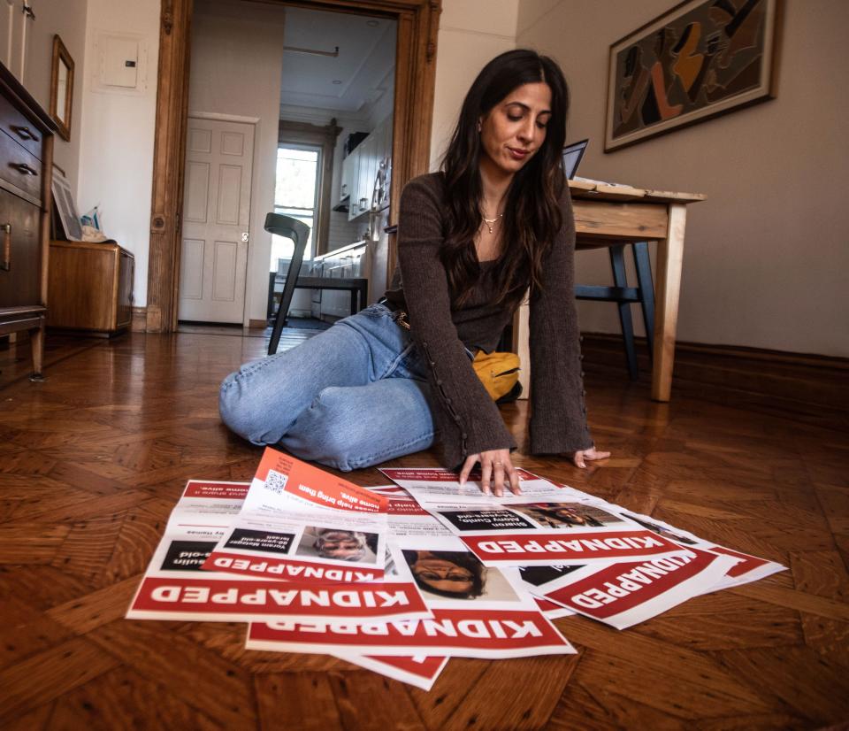 Alana Zeitchik, 38, looks at a poster of one her cousins who is being held captive by Hamas in the Gaza Strip. Zeitchik, photographed in her Brooklyn apartment Oct. 19, 2023, has six cousins that are currently being held by Hamas. 