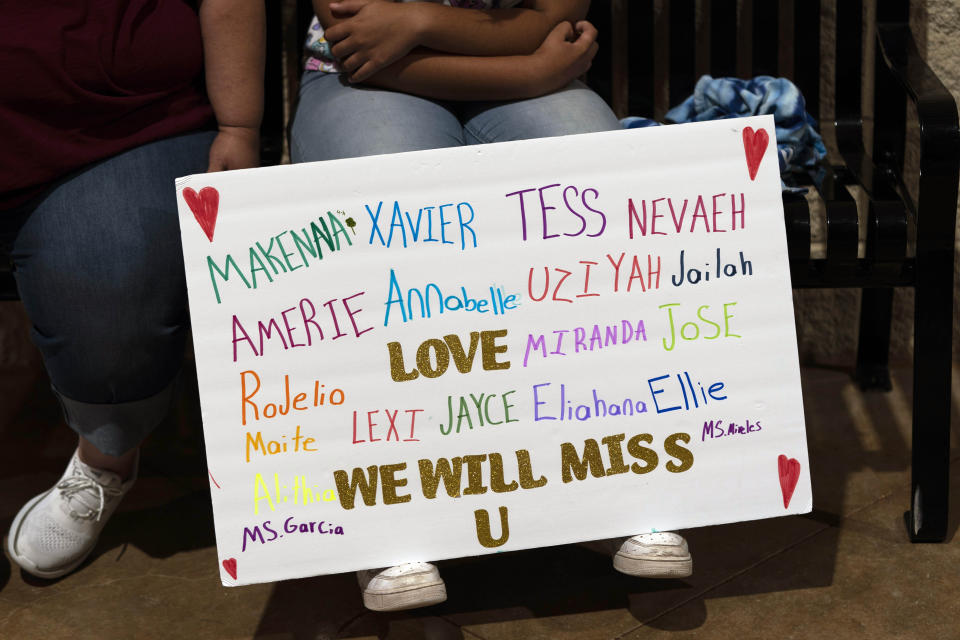 Stormy Flores, 11, sits with a sign bearing the names of the Robb Elementary School shooting victims during a prayer vigil in Uvalde, Texas, Wednesday, May 25, 2022.