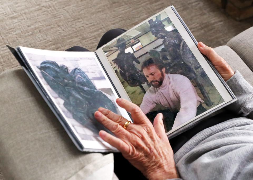 Virgil Villers looks through photos of his earlier pieces, including a portrait of himself with a sculpture done for a McDonald's owner in Painesville, Wednesday, March 27, 2024, in Norton, Ohio.