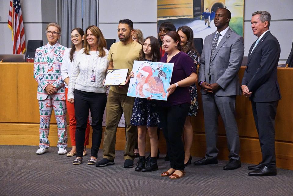 Abigail Lopez, a ninth-grader at John I. Leonard High School, poses with loved ones and school district leaders after winning the 2022 Superintendent’s Greeting Card Contest.