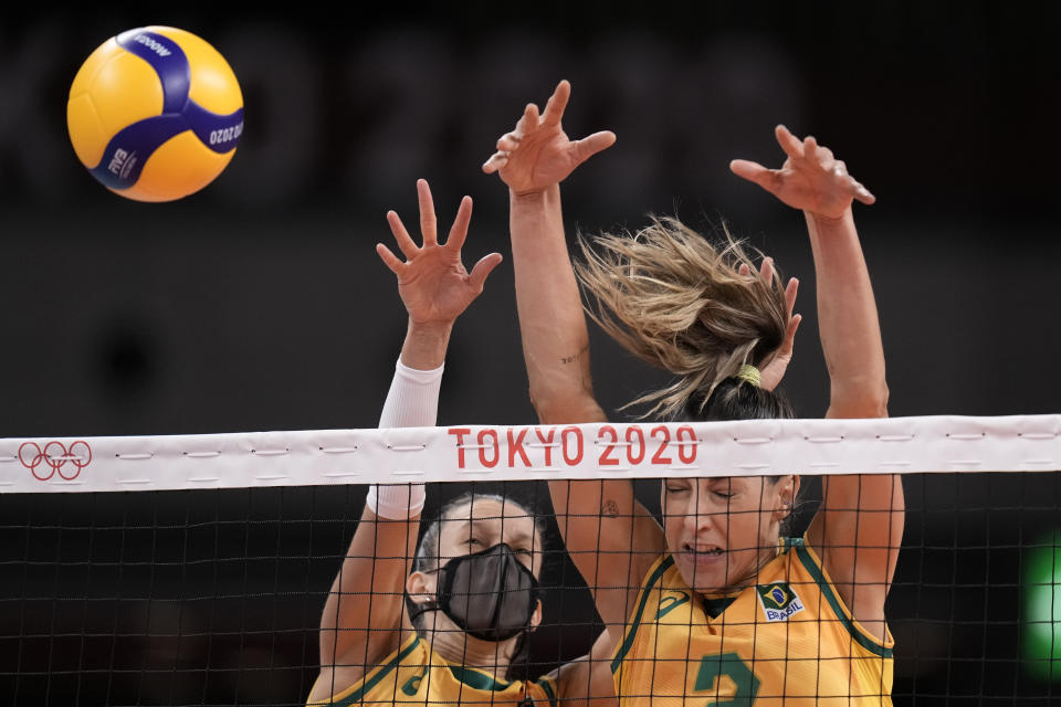 Brazil's Macris Fernanda Silva Carneiro and Caroline de Oliveira Saad Gattaz block at the net during a women's volleyball preliminary round pool A match against South Korea, at the 2020 Summer Olympics, Sunday, July 25, 2021, in Tokyo, Japan. (AP Photo/Manu Fernandez)