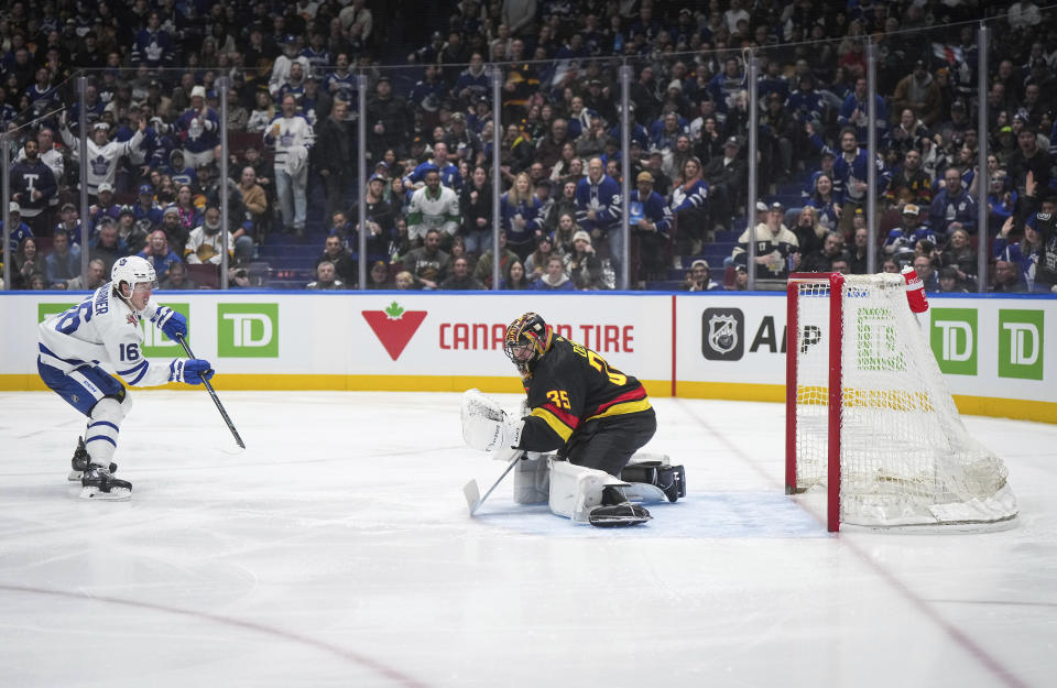 Toronto Maple Leafs' Mitchell Marner, left, scores a short-handed goal against Vancouver Canucks goalie Thatcher Demko, right, during the third period of an NHL hockey game in Vancouver, British Columbia, Saturday, Jan. 20, 2024. (Darryl Dyck/The Canadian Press via AP)
