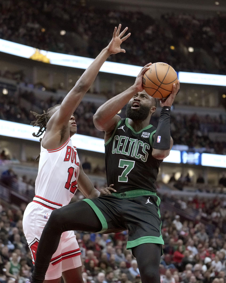 Boston Celtics' Jaylen Brown (7) drives to the basket as Chicago Bulls' Ayo Dosunmu, left, defends during the first half of an NBA basketball game Thursday, Feb. 22, 2024, in Chicago. (AP Photo/Charles Rex Arbogast)