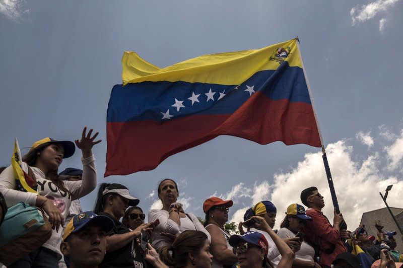 Supporters of Venezuelan opposition leader Juan Guaido demonstrated with a Venezuelan national flag as they waited for his return in Caracas in 2019. Today, there are currently 13 presidential candidates registered for this year's election. On Wednesday, the U.S. State Department said it is "deeply concerned" by the Venezuelan government's pattern of blocking opposition parties from registering candidates in the upcoming presidential election. File Photo by Marcelo Perez/UPI