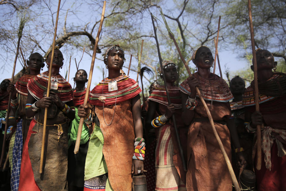 Samburu women sing under a tree as they make a daily pilgrimage to a reservoir where they spill milk on the parched landscape as an offering on Thursday, Oct. 13, 2022, in Samburu County, Kenya. They perform this ceremony every day until rain comes. (AP Photo/Brian Inganga)