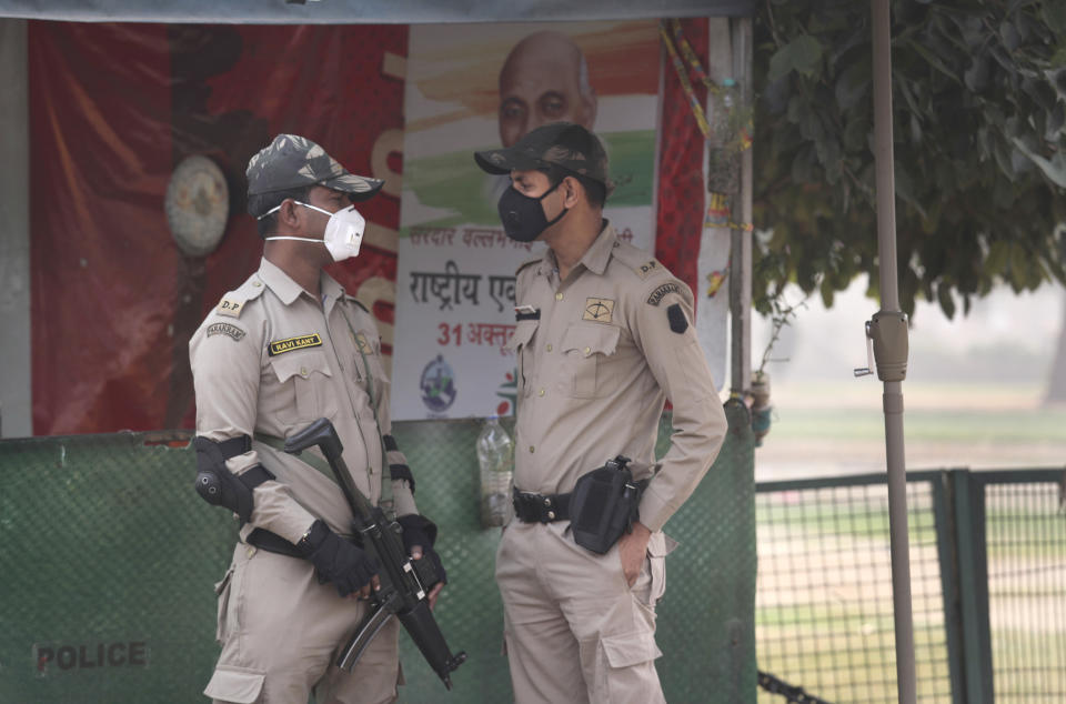 Delhi police commandos wear pollution mask and talk a day after Diwali festival, in New Delhi, India, Thursday, Nov. 8, 2018. Toxic smog shrouds the Indian capital as air quality falls to hazardous levels with tens of thousands of people setting off massive firecrackers to celebrate the major Hindu festival of Diwali on Wednesday night. (AP Photo/Manish Swarup)