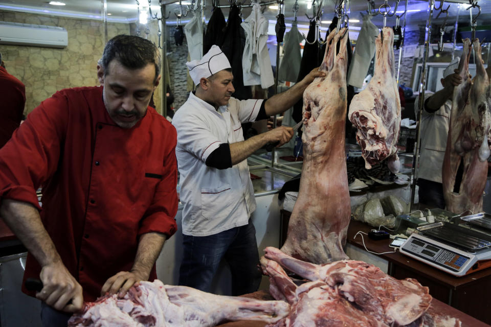 Hussein Esfira, centre, cuts the meat of a sheep inside the butchery in so called 'Little Syria', the nickname for Istanbul's central Aksaray neighbourhood, now home to many Syrians who escaped the civil war that has ravaged the country for the past six years, Saturday, April 8, 2017. Restaurants and shops with colorful Arabic signs offer respite to those who sorely miss their country and its delicacies.The country hosts three million Syrian refugees and its largest city, Istanbul, is home to some 480,000 of them. (AP Photo/Bram Janssen)